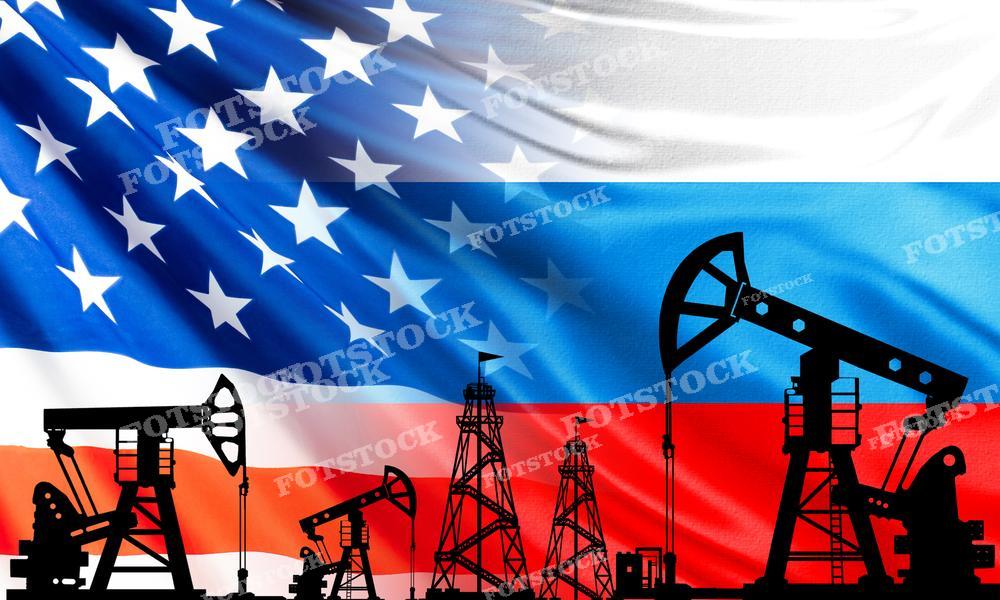 На фото виден американский флаг на фоне, поверх которого расположены силуэты нефтяных вышек и насосов, что подчеркивает важность нефтяной промышленности для экономики США. Это изображение может использоваться в статьях и аналитических материалах, посвященных энергетической политике, нефтедобыче и воздействию энергетического сектора на американскую экономику.